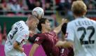 Einen Tag vor dem 90. Geburtstag von Kaiserslauterns Legende Fritz Walter gewann der 1. FCK mit 3:0 gegen Mönchengladbach. Torjäger Srdjan Lakic erzielte das 3:0, hier kämpft er gegen die Gladbacher Filip Daems (links) und Tobias Levels. Foto: dpa