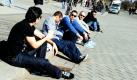 Touristen genießen auf einem Bordstein auf dem Pariser Platz in Berlin die Sonne. Der Frühling ist mit Temperaturen zwischen 10 und 14 Grad Celsius in der Hauptstadt angekommen. Foto: dpa