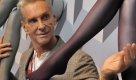 Der Modedesigner Wolfgang Joop steht am Dienstag (27.10.2009) in Berlin zwischen zwei an der Wand befestigten und mit Strümpfen angezogenen Kunststoffbeinen. Die Strümpfe sind so genannte Kompressionsstrümpfe und gehören zur neuen von Joop gestalteten Kollektion MJ-1 des Unternehmens Medi.
 Foto: dpa