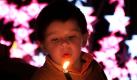Ein kleiner Junge sieht in Kolumbien eine Kerze während der Nacht der Kerzen an. Dieses Fest markiert den Beginn der Weihnachtszeit. Foto: dpa