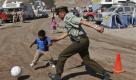 A police officer and a child play with a soccer ball at the camp where relatives of trapped miners wait for news outside the San Jose in Copiapo, Chile, Sunday, Oct. 3, 2010. Thirty-three miners have been trapped deep underground in the copper and gold mine since it collapsed on Aug. 5. (AP Photo/Roberto Candia) Foto: ap