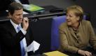 Aussenminister und Vizekanzler Guido Westerwelle (FDP) und Bundeskanzlerin Angela Merkel (CDU) unterhalten sich am Mittwoch  (10.02.10) in Berlin im Bundestag. Westerwelle begruesst die in London beschlossene Neuausrichtung des internationalen Afghanistan-Engagements. Mit dem Strategiewechsel stehe nun der zivile Wiederaufbau im Fokus der Anstrengungen und biete erstmals auch eine Abzugsperspektive ab Ende 2011, sagte Westerwelle am Mittwoch in einer Regierungserklaerung vor dem Bundestag in Berlin. (zu ddp-Text) Foto: Axel Schmidt/ddp *** Local Caption *** Foto: ddp