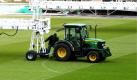 Im Innenraum des Bremer Weserstadions hängt ein Mitarbeiter von Stadtgrün eine Beleuchtungsanlage an einen Traktor. Um die Qualität des kürzlich neuverlegten Rasens zu verbessern, bekommt der Rasen zur Zeit Tag und Nacht eine Lichtdusche. Durch den Umbau des Stadions fehlt es dem Grün an Licht, weil die Tribünen zuviel Schatten werfen. Foto: dpa