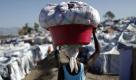 Eine Frau transportiert im Flüchtlingscamp Port-au-Prince ihr einziges Hab und Gut auf dem Kopf. Wie Millionen anderer hat sie bei dem Erdbeben auf Haiti alles verloren. Foto: ap