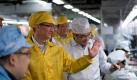 Apple-Chef Tim Cook lässt sich die Produktion bei Foxconn zeigen. Foto: Bowen Liu/Apple Foto: dpa