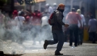 Ein Demonstrant mit einem Stein in der Hand: Während einer Protestveranstaltung in Tegucigalpa, in Honduras hat es bei Auseinandersetzungen mit den Sicherheitskräften bereits einen Toten gegeben. Foto: dpa