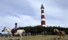 Freizeitsportler reiten am Donnerstag (22.07.10) auf der Insel Ameland (Niederlande) am Leuchtturm entlang. Ameland gehoert zu einer der fuenf bewohnten Inseln in der Nordsee. Foto: David Hecker/ddp Foto: ddp