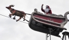 Ein als Nikolaus verkleideter Artist fährt in Berlin-Spandau mit einem Fahrrad, das als Rentierschlitten umdekoriert wurde, über ein Drahtseil. Der Weihnachstmarkt in der Altstadt-Spandau dauert noch bis zum 20. Dezember 2009. Foto: dpa
