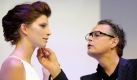 Es kommt nicht nur auf die Schuhe an: Das Jurymitglied der Castingshow Germanys next Topmodel, Rolf Scheider, schminkt während einer Modenschau Model Luca Gadjus. 
 Foto: ddp