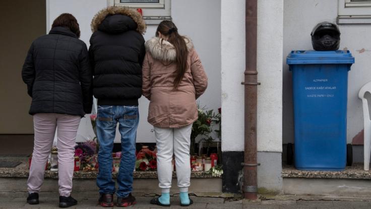 Trauernde Nachbarn und Freunde der Familie des Opfers stehen vor dem Haus, in dem die Tochter der Familie von ihrem Freund umgebracht worden war.