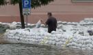 Ein Mann traegt am Donnerstag (27.05.10) hinter Sandsaecken an einer vom Oderwasser ueberfluteten Strasse in Eisenhuettenstadt in Brandenburg einen Sandsack. Brandenburgs Innenminister Rainer Speer (SPD) geht davon aus, dass die Deiche nicht so stark beansprucht werden wie zum Jahrhundert-Hochwasser von 1997. 'Wir werden einen halben Meter unter den historischen Staenden von 1997 bleiben', sagte auch Brandenburgs Landesumweltamtspraesident Matthias Freude. Nach derzeitiger Prognose werden zudem die Hochwasserscheitel der Warthe und der Oder nicht zusammentreffen. Der Pegel Ratzdorf erreichte Donnerstagmittag 6,21 Meter. (zu ddp-Text) Foto: Michael Urban/ddp Foto: ddp