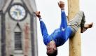 Maibaumkraxler Matthias Spiesberger umklammert in Freinberg, Österreich mit seinen Beinen einen Maibaum. Spiesbergers Ziel ist es, so schnell wie möglich den Maibaum hinaufzuklettern und in 15 Meter Höhe eine Glocke zu läuten. Dann wird seine Zeit gestoppt.
 Foto: ddp