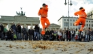 In der Uniform der Berliner Stadtreinigungsbetriebe tanzen Tänzer des Staatsballetts Berlin vor dem Brandenburger Tor im Rahmen der Aktion Die mit dem Laub tanzen. Foto: ddp