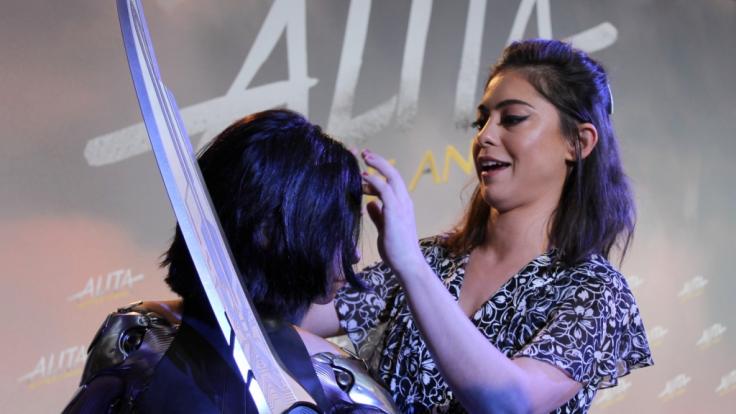 Rosa Salazar richtet ihrem künstlichen Ebenbild bei der Pressekonferenz die Haare.