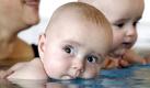 Skeptisch schaut der sechs Monate alte Rene (Mitte) vor dem Abtauschen neben seiner Mutter Heike Urbach und seinem Zwillingsbruder Robin beim Babyschwimmen in der Elternschule des Helios-Klinikums in Erfurt. Babyschwimmen kann den Gleichgewichtssinn und das Körpergefühl von Kindern dauerhaft verbessern. Darauf deutet eine Studie aus Island hin, in der Psychologen 38 Kinder miteinander verglichen. Foto: ap