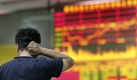 Ein Investor schaut nachdenklich auf den Monitor der Aktienkurse in der Börse von Shanghai. Foto: ap
