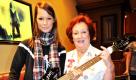 Die österreichische Musikerin Christina Stürmer und die Hard Rock Botschafterin und Kellnerin der ersten Stunde Rita Gilligan posieren mit einem Bass im Hard Rock Cafe München. Im Zuge des neunten Geburtstags besuchte die Musikerin die Kultlocation und übergab eigene Erinnerungsstücke für die Sammlung des Hard Rock Cafes. Foto: dpa