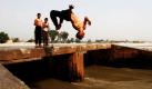 Ein afghanischer Junge springt mit einem gewagten Salto in einen Kanal in Jalalabad, östlich von Kabul. Foto: ap