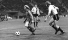 Dabei war Hoeneß auf dem Feld selbst ein begnadeter Spieler. Einer seiner besten Auftritte: Bayerns kreativer Offensivspieler (links) gegen Dresdens Fußballarbeiter Eduard Geyer im Achtelfinal-Hinspiel des Europapokals der Landesmeister. Der FC Bayern gewann die Partie 4:3 und erreichte durch ein 3:3 im Rückspiel das Viertelfinale. Zweifacher Torschütze: Uli Hoeneß. Foto: dpa