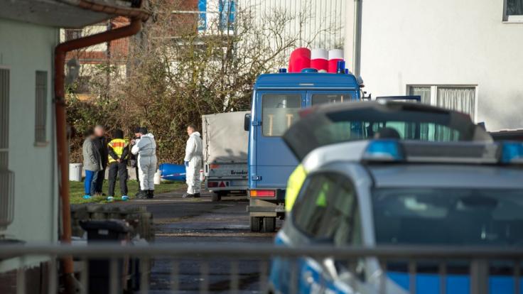 Polizisten stehen auf dem umzäunten Grundstück. Dort hatten Nachbarn das tote Rentner-Ehepaar gefunden.