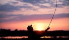 So schön kann angeln sein: Im Sonnenuntergang bei Wallen, im Kreis Dithmarschen, geht ein Angler auf Fischfang. Foto: Christian Charisius Foto: dpa