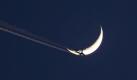 Knapp daneben: Ein Flugzeug fliegt über Nürnberg am Mond vorbei. Foto: Daniel Karmann Foto: dpa