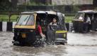 An auto driver plays with water on a flooded street as he ferries schoolchildren in a rain in Jammu, India, Thursday, Aug. 5, 2010. (AP Photo/Channi Anand) 

 Foto: ap