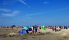Der Strand der Nordsee ist in St. Peter Ording bei strahlendem Sonnenschein mit Menschen bevölkert. Bei der ungewöhnlichen Hitze ist die Wassertemperatur um 22 Grad eine Wohltat. Foto: ap