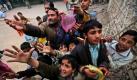 Menschen in Pakistan versuchen gespendete Süßigkeiten in Islamabad zu bekommen. 
 Foto: ap