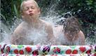 Der achtjaehrige Hannes (l.) und der sechsjaehrige Jeannot planschen am Mittwoch (31.07.02) in einem Hamburger Garten in ihrem Privatpool. So wie diese beiden Jungs zieht es die Hanseaten bei hochsommerlichen Temperaturen um die 30 Grad hinein ins 'kuehle Nass'. Glaubt man den Meteorologen soll es mit den warmen Temperaturen zum Ende der Woche erstmal vorbei sein.
 Foto: ddp