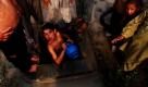Pakistanische Jugendliche stehen in Islamabad an, um sich in einem Wasserloch zu duschen.  Foto: ap