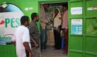 In Nairobi tätigen Kunden der Firma Safaricom in einem Container Überweisungen per Mobiltelefon. M-Pesa nennt sich das System und wurde in Kooperation mit Vodafone entwickelt, um Kunden ohne reguläres Bankkonto bargeldlose Zahlungen über Mobiltelefone zu ermöglichen.
  Foto: dapd