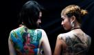 Die Thailänderinnen Yanisa Suayvicha (links) und Walanlak Kumngern zeigen gern viel Haut  zumindest auf Tattoo-Messen, wie hier in Bangkok. Foto: dapd