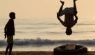 Jungen zeigen am Strand von Madras (Indien) Kunststücke. Nathan G. Foto: dpa