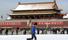 A Chinese boy runs past Tiananmen Square, covered in snow, in Beijing, China, Tuesday, Nov. 10, 2009. (AP Photo/Andy Wong) Foto: ap