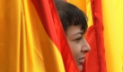 Ein Anhänger der ultrarechten spanischen Falangisten lugt bei einer Demonstration in Pamplona zwischen spanischen Nationalflaggen hervor. Foto: ap