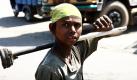 Ein indisches Kind schaut einem Fotografen auf dem Weg zur Arbeit im indischen Jammu in die Kamera. Am 12. Juni ist der Internationale Tag gegen Kinderarbeit.  Foto: dpa