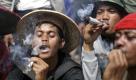 Tobacco farmers smoke homemade cigarettes during a protest against a bill on stricter tobacco control outside the presidential palace in Jakarta, Indonesia, Wednesday, July 13, 2011. Hundreds of farmers staged the protest claiming that the bill that would ban cigarette advertising and sponsorship, prohibit smoking in public, and add graphic images to packaging, would lead to massive losses of job that would affect thousands of tobacco farmers and their families in Indonesia, the world's third-largest tobacco consumer. (AP Photo/Dita Alangkara) Foto: dapd