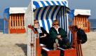 Am Ostseestrand von Warnemünde nutzen Touristen das sonnige und milde Wetter für eine Rast in einem der allerletzten Strandkörbe, die sie noch erwischen konnten. Bis Sonntag stehen die letzten Strandmöbel am Wasser, dann kommen sie ins Winterquartier. Foto: dpa