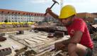 Ein Bauarbeiter schwingt den Hammer auf der Baustelle für die neue Schwimmhalle des SV Halle, aufgenommen am Dienstag (29.06.2010) in Halle (Saale). Der Grundstein für die zwölf Millionen teure Trainingsschwimmhalle wurde am gleichen Tag gelegt. Wegen zahlreicher Baumängel war die alte Schwimmhalle auf dem Sportkomplex des SV Halle abgerissen worden. In der maroden Schwimmhalle hatten Doppel-Weltmeister Paul Biedermann und andere Leistungssportler trainiert. Anfang 2011 sollen sie nach Angaben der Baufirma bereits in der neuen Schwimmhalle trainieren können. Foto: Peter Endig dpa/lah +++(c) dpa - Bildfunk+++ Foto: dpa