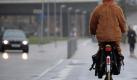 Ein verkleidetet Narr fährt auf einem Fahrrad in Düsseldorf am Rheinufer entlang. Die Jecken lassen sich vom Schmuddelwetter nicht schrecken. Foto: Federico Gambarini Foto: dpa
