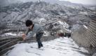 Auch in Fernost hält der Winter an. Touristen erklimmen die mit Schnee bedeckte Chinesische Mauer. Foto: ap