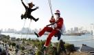 Als Weihnachtsmänner verkleidete Hochhaus-Fensterputzer posieren vor einem Einkaufszentrum in Tokio. Foto: Franck Robichon Foto: dpa