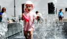 Die kleine Maria-Luisa (1) spielt zwischen den Fontänen des Brunnens am St.-Jakobs-Platz in München. Das Wetter bleibt auch zu Wochenbeginn in weiten Teilen Deutschlands sonnig und warm, berichtet der Deutsche Wetterdienst. Foto: dpa