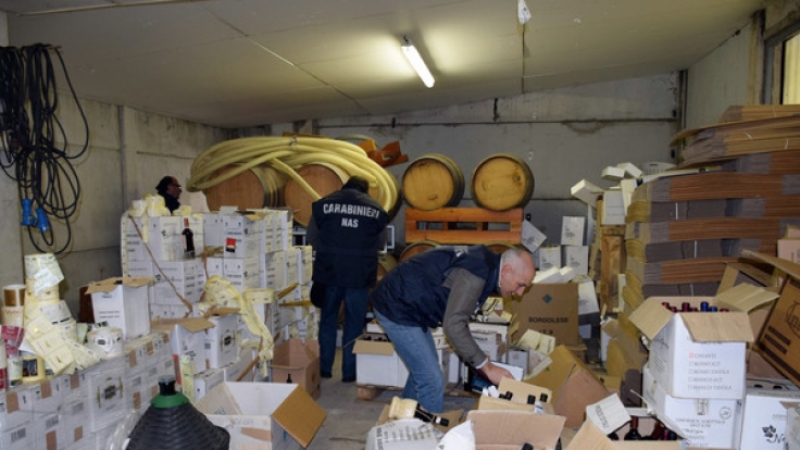 Polizisten durchsuchen in der Nähe von Florenz (Italien) ein Lager, in dem gefälschter Rotwein entdeckt wurde.