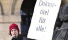 Ein Demonstrant haelt am Samstag (05.03.11) in Dresden vor dem Rathaus ein satirisches Schild mit der Aufschrift 'Doktortitel fuer alle!'. Guttenberg hatte seinen Ruecktritt erklaert, weil er entgegen seiner ehrenwoertlichen Erklaerung Teile seiner Dissertation aus anderen Quellen abgeschrieben hatte, ohne dies kenntlich zu machen. Die Universitaet Bayreuth hat ihm seinen Doktortitel deswegen aberkannt. (zu dapd-Text) Foto: Matthias Rietschel/dapd Foto: dapd