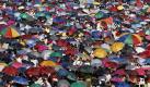 Bei einem Treffen von Christen im philippinischen Manila haben tausende Teilnehmer ihre Regenschirme aufgespannt, um sich vor der Sonne zu schützen. Foto: Dennis M. Sabangan Foto: dpa