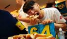 Futtern bis nichts mehr geht: Der vormalige Champion des berühmten Hot-Dog-Wettessens Takeru Kobayashi aus Nagano in Japan führt in New York seinen robusten Magen vor, während der Titelverteidiger Joey Chestnut im Hintergrund Fragen der Medien beantwortet. Kobayashi, der den Wettbewerb bis zum Jahr 2007 sechs Jahre lang gewann, will auch am jährlichen Wettbewerb auf Coney Island an diesem Wochenende teilnehmen, ist aber mit dem Wettbewerbs-Vertrag nicht ganz einverstanden, wie eine Nachrichtenagentur berichtet. Foto: ap