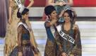 In this Friday, Oct. 8, 2010 photo Miss Indonesia 2009 Cory Sandioriva, center, puts her tiara on the head of Nadine Alexandra Dewi Ames, the winner of Miss Indonesia pageant 2010, as Miss Universe 2010 Ximena Navarrete of Mexico, left, looks on during the final night of the beauty contest in Jakarta, Indonesia. (AP Photo/Irwin Fedriansyah) Foto: ap
