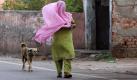 Eine Frau im indischen Amritsar sucht Schutz unter ihrem Tuch. Ein Staubsturm fegte am frühen Morgen durch die Straßen der Stadt. Foto: Raminder Pal Singh Foto: dpa